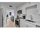 Modern kitchen with white cabinets, stainless steel appliances, and an open layout leading to the dining area at 100 S Interlachen Ave # 410F, Winter Park, FL 32789