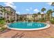 Community pool with surrounding lounge chairs, lush landscaping, and condo building views at 100 S Interlachen Ave # 410F, Winter Park, FL 32789