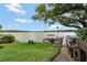 View of the lakefront with a dock, seating, and stairs leading down to the water, framed by lush greenery at 100 S Interlachen Ave # 410F, Winter Park, FL 32789