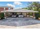A two-car carport in front of a charming brick house, perfect for shade or to keep the rain off of your car at 1002 Lake Elbert Se Dr, Winter Haven, FL 33880