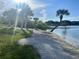 Scenic waterfront view featuring palm trees, a sandy beach, and a picturesque pier, perfect for relaxation at 1002 Lake Elbert Se Dr, Winter Haven, FL 33880