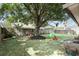 Backyard features an expansive lawn with play equipment and mature shade trees at 10049 Custer Cir, Orlando, FL 32817