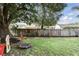 Spacious backyard with a grass lawn, mature shade trees, and a fenced perimeter at 10049 Custer Cir, Orlando, FL 32817