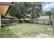 Large backyard features a grass lawn, mature shade trees, a screened patio and a fenced perimeter at 10049 Custer Cir, Orlando, FL 32817