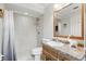 Bathroom with tiled walk-in shower and wood vanity with decorative accents and modern fixtures at 10049 Custer Cir, Orlando, FL 32817