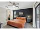 Cozy main bedroom featuring a decorative accent wall, ceiling fan, and sliding glass door to the outside at 10049 Custer Cir, Orlando, FL 32817