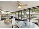 Screened patio with a ceiling fan, table with four chairs, grill, and picnic table at 10049 Custer Cir, Orlando, FL 32817