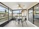 Screened in patio with a ceiling fan, a table with four chairs and views of the back yard at 10049 Custer Cir, Orlando, FL 32817