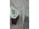 Modern bathroom with dual sinks, illuminated mirrors, tiled floors, and a glass-enclosed shower at 1005 Randall St, Orlando, FL 32805