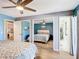 Bright bedroom features a ceiling fan, wood-look floors, and mirrored closet doors, with ensuite bathroom access at 1021 Whalebone Bay Dr, Kissimmee, FL 34741