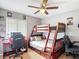 The room has a bunk bed with a desk next to a window with a wood floor and ceiling fan at 1021 Whalebone Bay Dr, Kissimmee, FL 34741