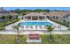 Aerial view of a community pool, surrounded by palm trees, lounge chairs, and green space at 1021 Whalebone Bay Dr, Kissimmee, FL 34741