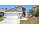 Charming single Gathering home featuring an attached garage, manicured lawn, and inviting curb appeal at 1021 Whalebone Bay Dr, Kissimmee, FL 34741