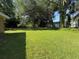 Lush green backyard surrounded by mature trees, providing a serene outdoor space at 1108 Bear Lake Rd, Apopka, FL 32703