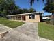 Single-story home with a covered front porch and a driveway leading to a carport at 1108 Bear Lake Rd, Apopka, FL 32703