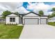Charming home featuring a two-car garage, inviting facade, and manicured lawn at 13312 Sw 41St Ct, Ocala, FL 34473
