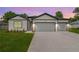 Charming home featuring a two-car garage, inviting facade, and manicured lawn at 13312 Sw 41St Ct, Ocala, FL 34473