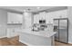 Modern kitchen with white cabinets, stainless steel appliances, and a large center island at 13312 Sw 41St Ct, Ocala, FL 34473