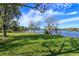 Lush green backyard with trees framing a view of the serene lake and its charming boat dock at 13377 Lake Butler Blvd, Winter Garden, FL 34787