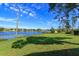 Expansive backyard with lush grass and mature trees leading to a beautiful lake with a charming boat dock at 13377 Lake Butler Blvd, Winter Garden, FL 34787