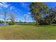 Wide green backyard with shade trees provides peaceful views of the waterfront and docks, perfect for outdoor enjoyment at 13377 Lake Butler Blvd, Winter Garden, FL 34787