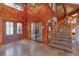 Grand foyer with a striking wood accent wall, stone floors, a modern staircase, and a bright entryway at 13377 Lake Butler Blvd, Winter Garden, FL 34787