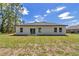 White home showcasing a sliding glass door and windows against a blue sky backdrop at 13430 Sw 88Th Ter, Ocala, FL 34473