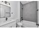 Bathroom boasts single vanity with modern fixtures and a shower and bathtub combo featuring gray tiling at 13430 Sw 88Th Ter, Ocala, FL 34473