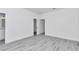 A bedroom with hardwood floors, neutral walls, white trim and closet doors, with a doorway into a bathroom at 13430 Sw 88Th Ter, Ocala, FL 34473