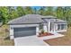 Stylish single-story home featuring a modern design, a two-car garage, and manicured landscaping at 13430 Sw 88Th Ter, Ocala, FL 34473