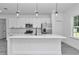 Contemporary eat in kitchen featuring white cabinets, sleek black hardware, and stainless steel appliances at 13430 Sw 88Th Ter, Ocala, FL 34473