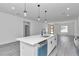 Eat in kitchen with a large island featuring white cabinets, sleek black hardware, and modern pendants at 13430 Sw 88Th Ter, Ocala, FL 34473