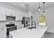 Modern eat in kitchen featuring white cabinets, sleek black hardware, and stainless steel appliances at 13430 Sw 88Th Ter, Ocala, FL 34473