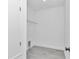 Bright laundry room featuring a metal shelf and gray hardwood floors at 13430 Sw 88Th Ter, Ocala, FL 34473