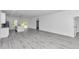 Open-concept living area with wood floors, neutral paint and a kitchen in the background, leading to sliding glass doors at 13430 Sw 88Th Ter, Ocala, FL 34473