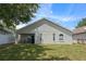 Back of house featuring a covered patio, sliding glass door, arched windows, and a large grassy yard at 135 Andrews Rd, Sanford, FL 32773