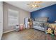 Bedroom with wood-look floors, a large window, a baby crib, and toys at 135 Andrews Rd, Sanford, FL 32773