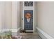 Close-up of a stylish front door with seasonal wreath and decorative pumpkins at 135 Andrews Rd, Sanford, FL 32773