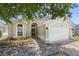 Inviting one-story home featuring a well-maintained yard, attached garage, and covered entrance at 135 Andrews Rd, Sanford, FL 32773
