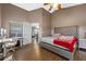 This main bedroom includes a vaulted ceiling, a tufted headboard, wood-look floors, and a desk at 135 Andrews Rd, Sanford, FL 32773