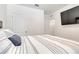 Bright bedroom featuring a TV, neutral walls, and striped bedding for a modern style at 1535 Barberry Dr, Kissimmee, FL 34744