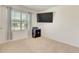 Bright bedroom features a large window, neutral carpet, and a wall-mounted TV at 1535 Barberry Dr, Kissimmee, FL 34744