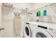 Efficient laundry room with modern washer, dryer, ironing board and ample shelving for storage at 1535 Barberry Dr, Kissimmee, FL 34744