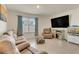 Cozy living room featuring tile flooring, a large TV, and comfortable seating for relaxing and entertaining at 1535 Barberry Dr, Kissimmee, FL 34744
