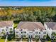 Scenic aerial view of modern townhomes, lush landscaping, and surrounding treeline at 17230 Blessing Dr, Clermont, FL 34714