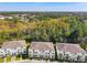 Aesthetic aerial view of modern townhomes showcasing lush landscaping and tree coverage at 17230 Blessing Dr, Clermont, FL 34714