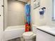 Tiled bathroom with tub and shower, and an ocean-themed shower curtain and wall art at 17230 Blessing Dr, Clermont, FL 34714