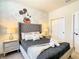 Bedroom features a king bed with decorative pillows and cartoon wall art at 17230 Blessing Dr, Clermont, FL 34714
