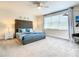 Spacious primary bedroom with a plush tufted headboard, side tables, and large windows at 17230 Blessing Dr, Clermont, FL 34714