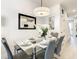 Stylish dining room with glass table, seating for six, and modern decor at 17230 Blessing Dr, Clermont, FL 34714